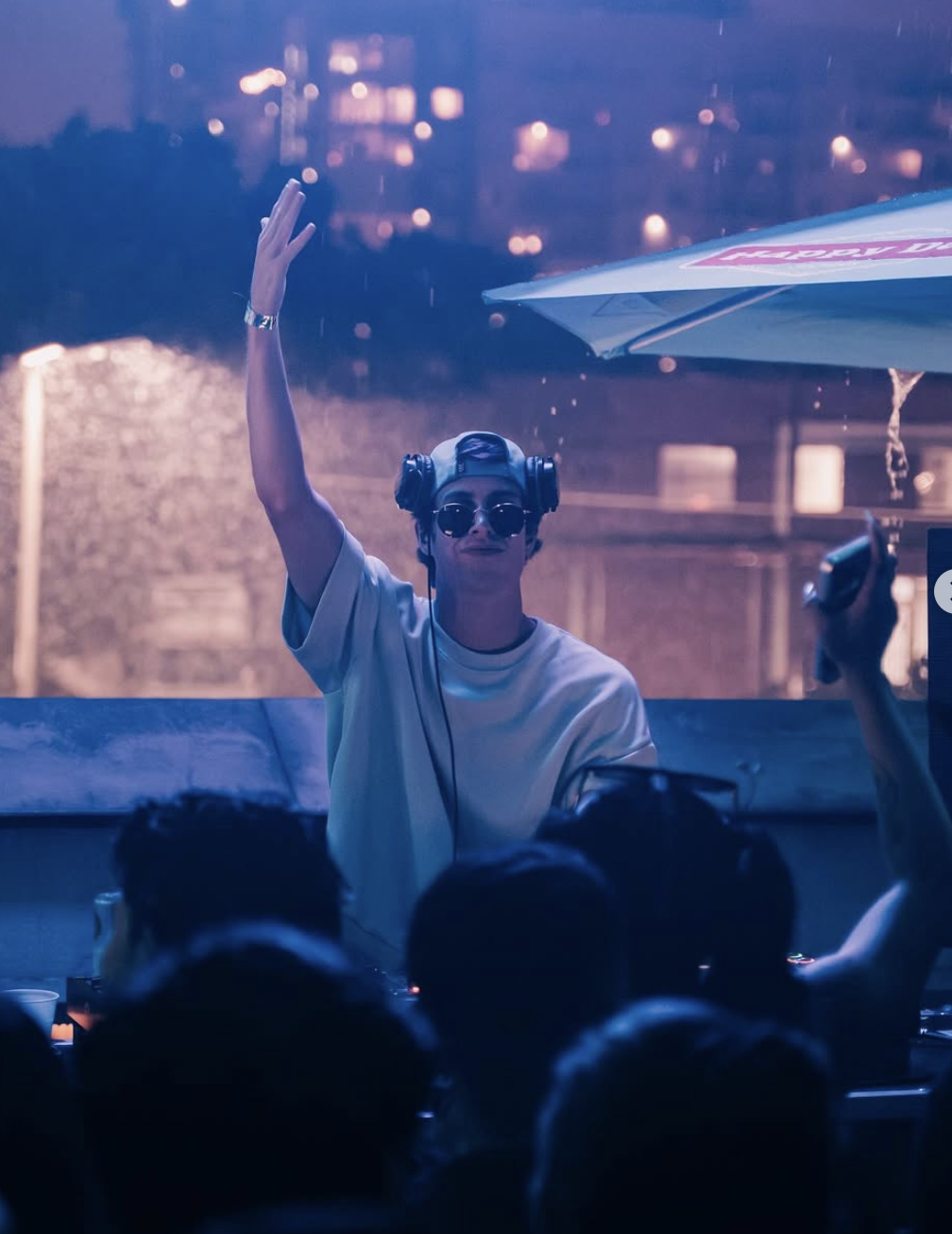 DJ FITZY performing in headphones and sunglasses with one arm raised, from his supplied photograph